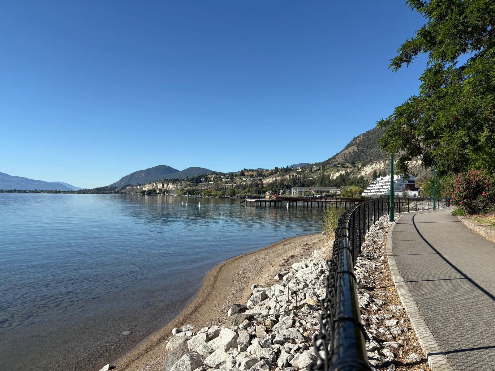 Calm Okanagan waterfront, hillside cliffs and a lakeside path