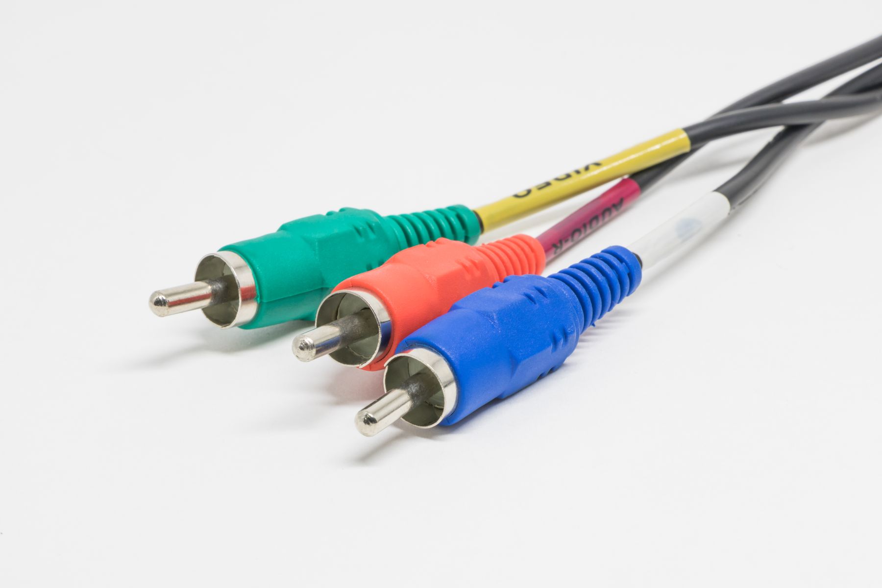 Colour-coded analogue audio and video cables arranged on a white surface.