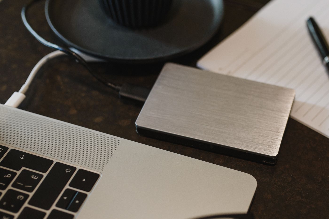 A portable external drive connected to a laptop for computer backup storage.