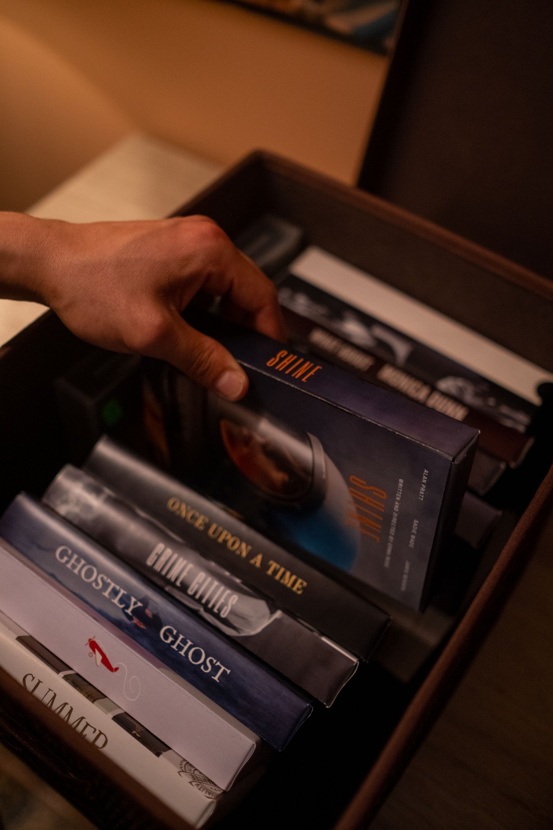 A person choosing from a large collection of stacked VHS videotapes.
